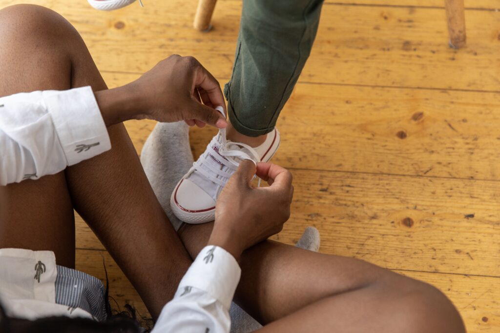 Kind übt selbstständig, die Schuhe zu binden