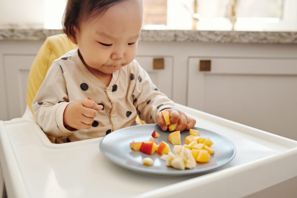 Kleines Kind isst gesundes Obst zum Frühstück