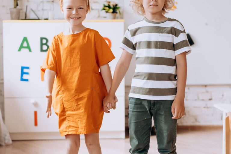 Zwei Kinder halten Hände als Zeichen der Freundschaft