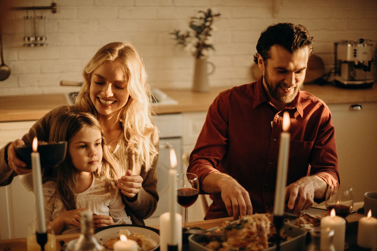 Eine Familie sitzt gemeinsam am Tisch und isst zusammen